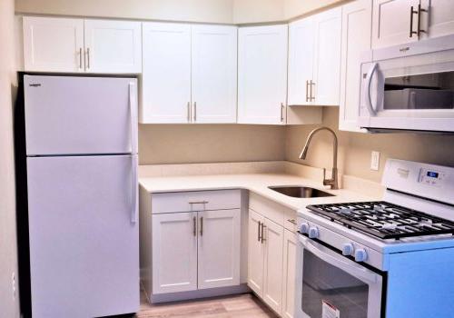 White kitchen with white countertops and modern appliances